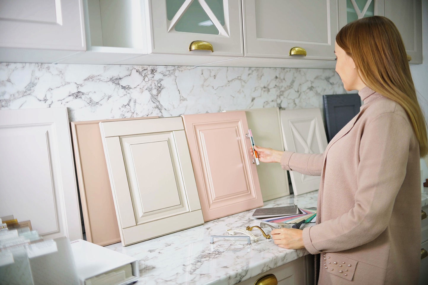 Home improvement concept. Woman choosing the facades and handles for her kitchen cabinets.