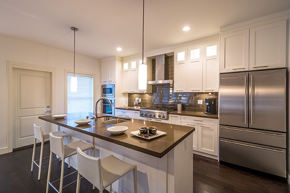 Modern, bright, clean, kitchen interior with stainless steel appliances in a luxury house.