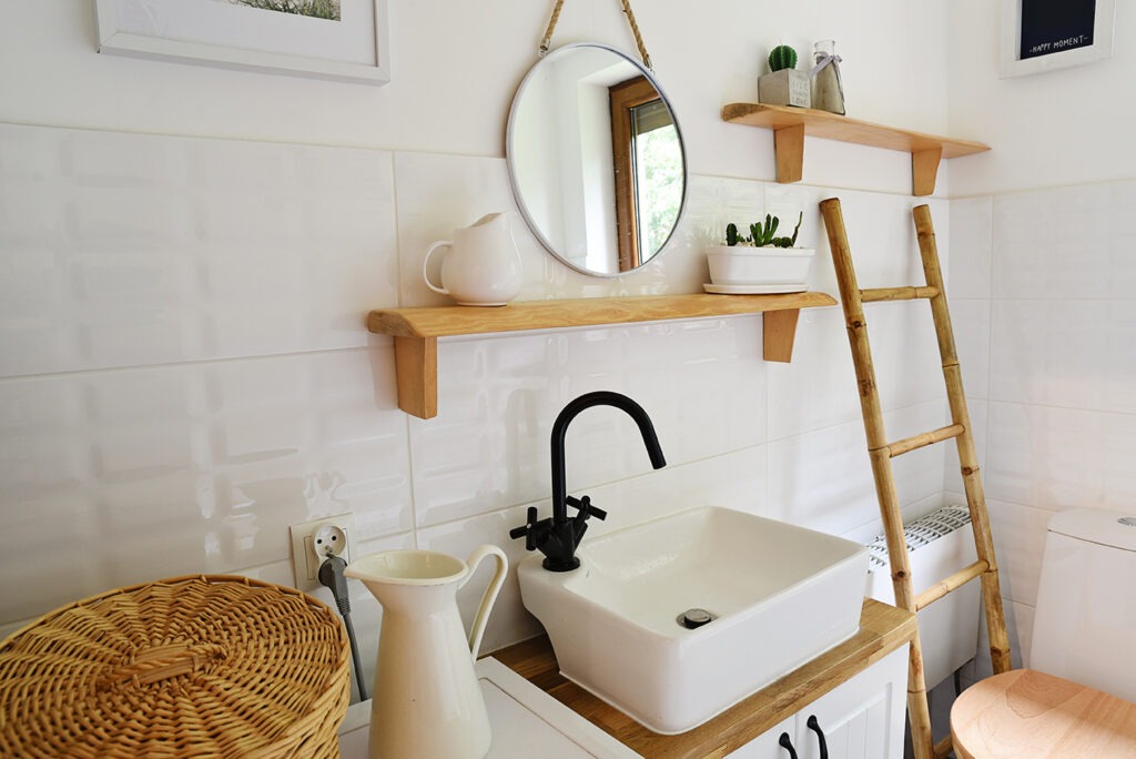 Interior of modern small bathroom with wooden decor and white color in vintage style. Small bathroom in cottage.