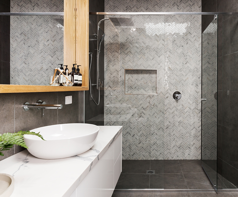 Marble mosaic herringbone tiled shower feature wall in a contemporary bathroom