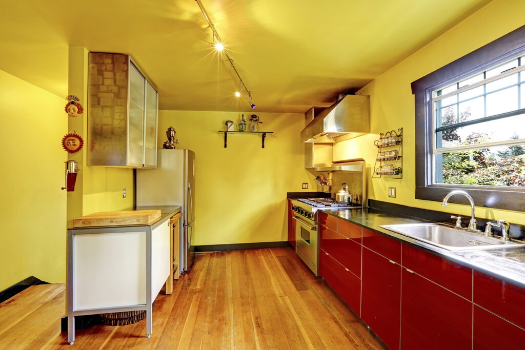 Kitchen room interior with yellow walls and red cabinets. Countryside house