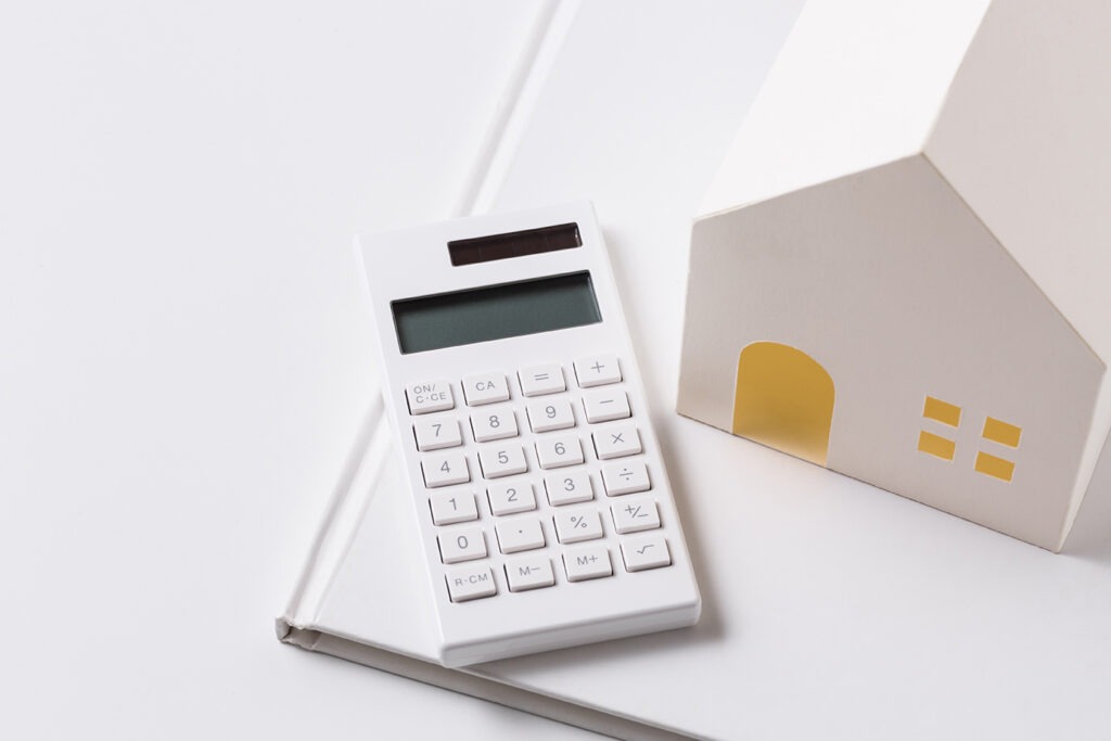 paper house and calculator on white background