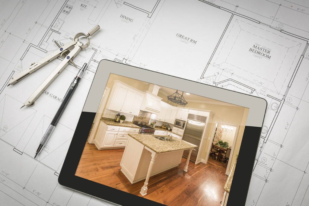 Computer Tablet Showing Finished Kitchen Sitting On House Plans With Pencil and Compass.