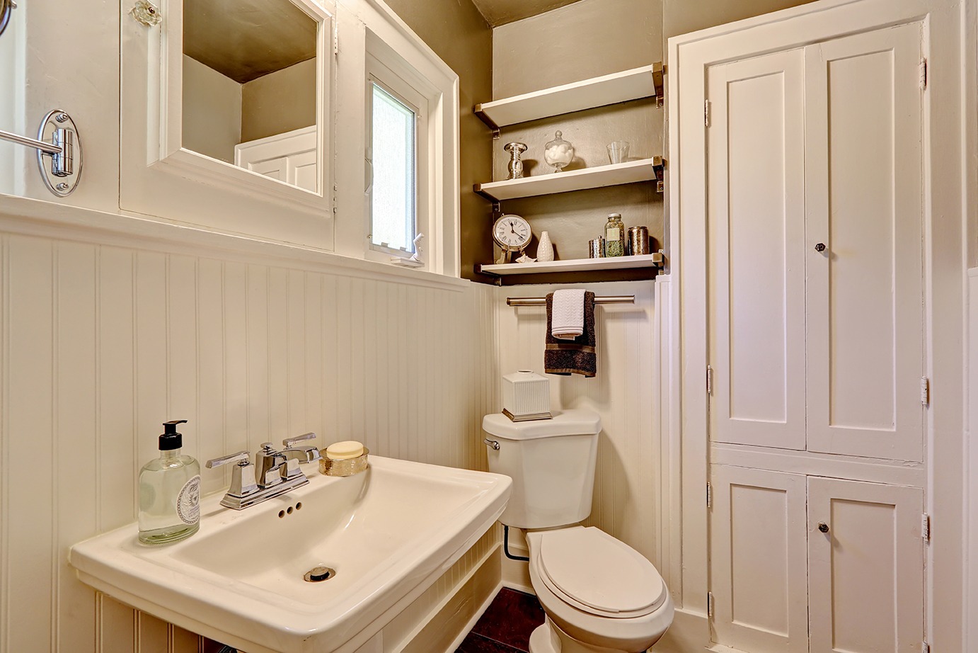 Simple bathroom interior in white color with washbasin stand and toilet.