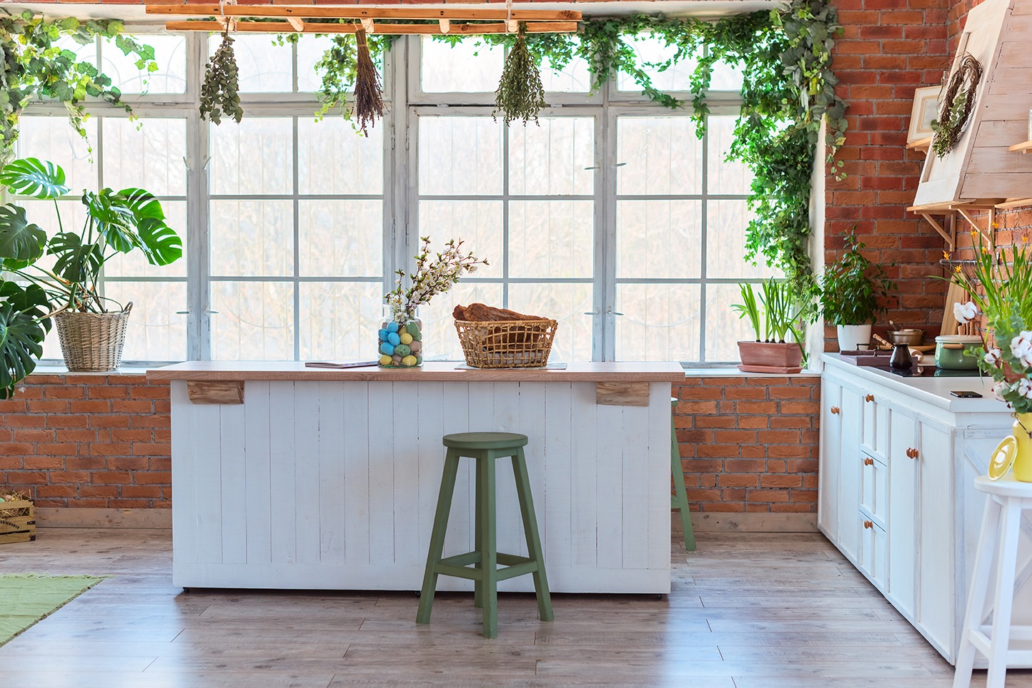 Kitchen in loft style with big window, decorated for Easter, brick wall, interior details